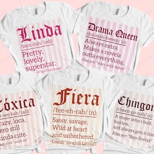 May include: White t-shirts with various definitions in pink and brown text. The shirts include the words "Linda", "Drama Queen", "Tóxica", "Fiera", and "Chingona", each with a definition and additional phrases.