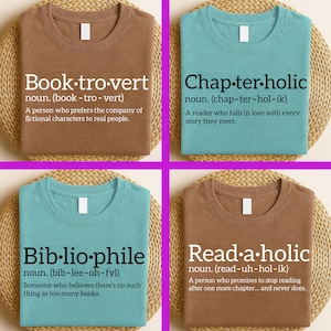 Può includere: Quattro magliette con parole e definizioni relative ai libri. Le magliette sono marroni e verde acqua, ognuna con una parola diversa in bianco: Book-tro-vert, Chap-ter-holic, Bib-lio-phile e Read-a-holic. Le magliette sono esposte su una superficie circolare intrecciata.