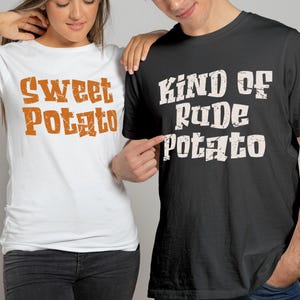 May include: A white t-shirt with the text "Sweet Potato" in orange lettering and a black t-shirt with the text "Kind of Rude Potato" in white lettering. The shirts are worn by two people.