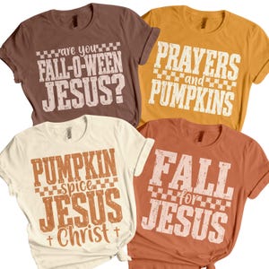 May include: Four short-sleeved crew neck t-shirts in brown, mustard yellow, cream, and burnt orange. Each shirt features distressed white or brown text with checkerboard accents. The phrases include 'are you FALL-O-WEEN JESUS?', 'PRAYERS and PUMPKINS', 'PUMPKIN spice JESUS Christ', and 'FALL for JESUS'.
