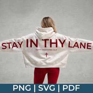 Könnte beinhalten: Ein hellgrauer Kapuzenpullover mit den Worten "STAY IN THY LANE" in Rot auf dem Rücken. Darunter steht "PETTY PROVERBS 24:7" und ein Kreuzsymbol. Die Person trägt rote Leggings.