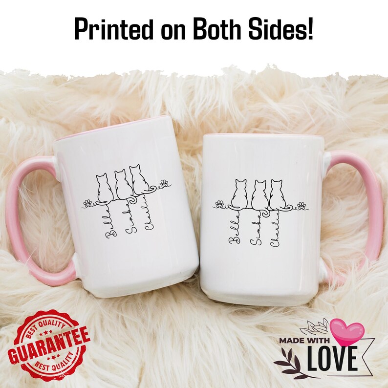 May include: Two white ceramic mugs with pink handles and interiors. Each mug features a black line drawing of three cats and the names "Bella", "Sunday", and "Charlie". The text "Printed on Both Sides!" is at the top.
