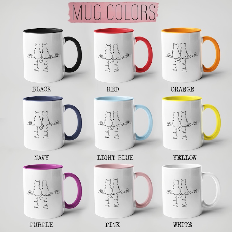 May include: White ceramic mugs with colored handles and interiors, featuring a black line drawing of two cats and the text "Loki & Nala." The mugs come in various colors, including black, red, orange, navy, light blue, yellow, purple, pink, and white.