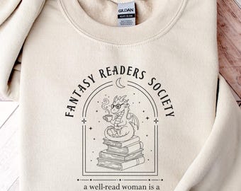 May include: A cream-colored sweatshirt with the text "FANTASY READERS SOCIETY" in a circular design. The design includes a dragon reading a book. Below the design is the text "a well-read woman is a dangerous creature."