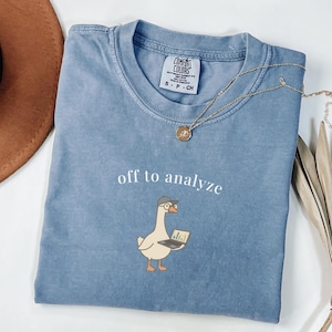 Op de afbeelding: Een set van drie keramische mokken met een gespikkelde, matte afwerking. De mokken zijn in de kleuren crème, lichtgrijs en donkergrijs. Elke mok heeft een eenvoudig, minimalistisch ontwerp, perfect voor koffie of thee.