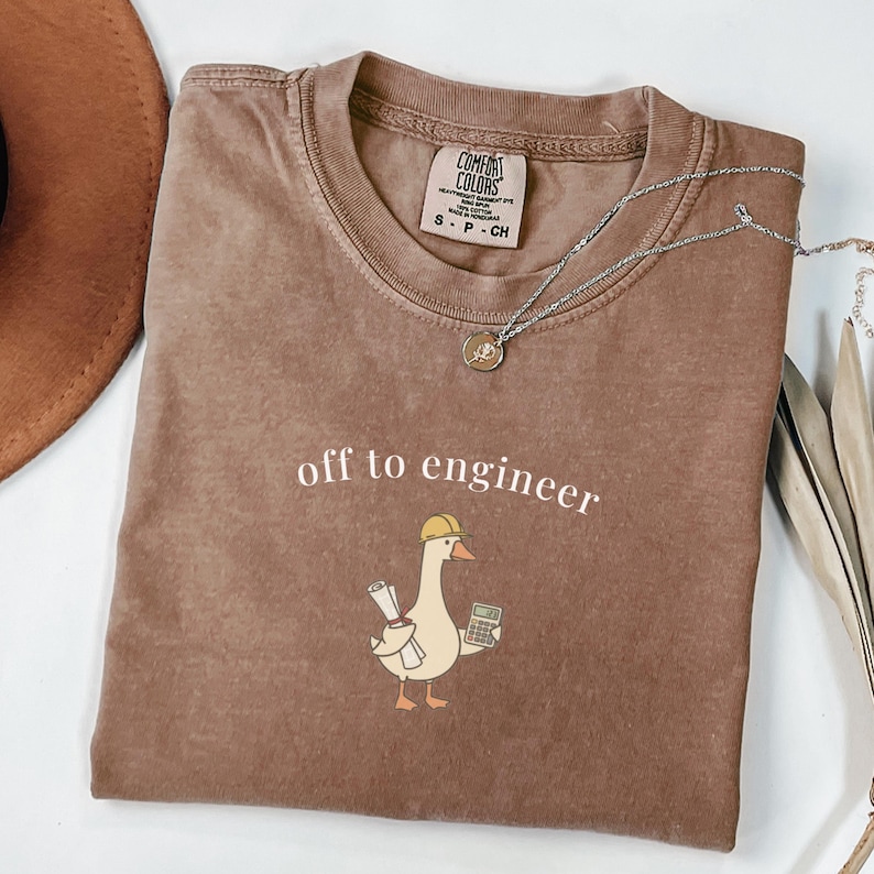 Brown t-shirt with "off to engineer" and a duck with calculator.