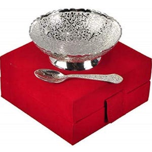 May include: A silver serving bowl with detailed floral patterns, a matching spoon, and a red velvet box. The bowl is on a pedestal base. The spoon and bowl share a matching design.