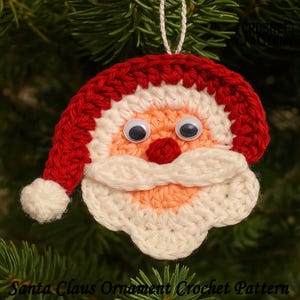 May include: A handmade crochet Santa Claus ornament with a red hat and beard, white mustache, and googly eyes. The ornament is hanging on a Christmas tree. The text "Santa Claus Ornament Crochet Pattern" is at the bottom.