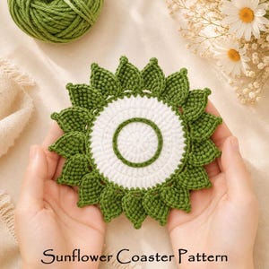 May include: A round, crocheted coaster featuring a white center with a green circular border, surrounded by a ring of green, leaf-shaped petals. The text "Sunflower Coaster Pattern" is printed in black at the bottom of the image.