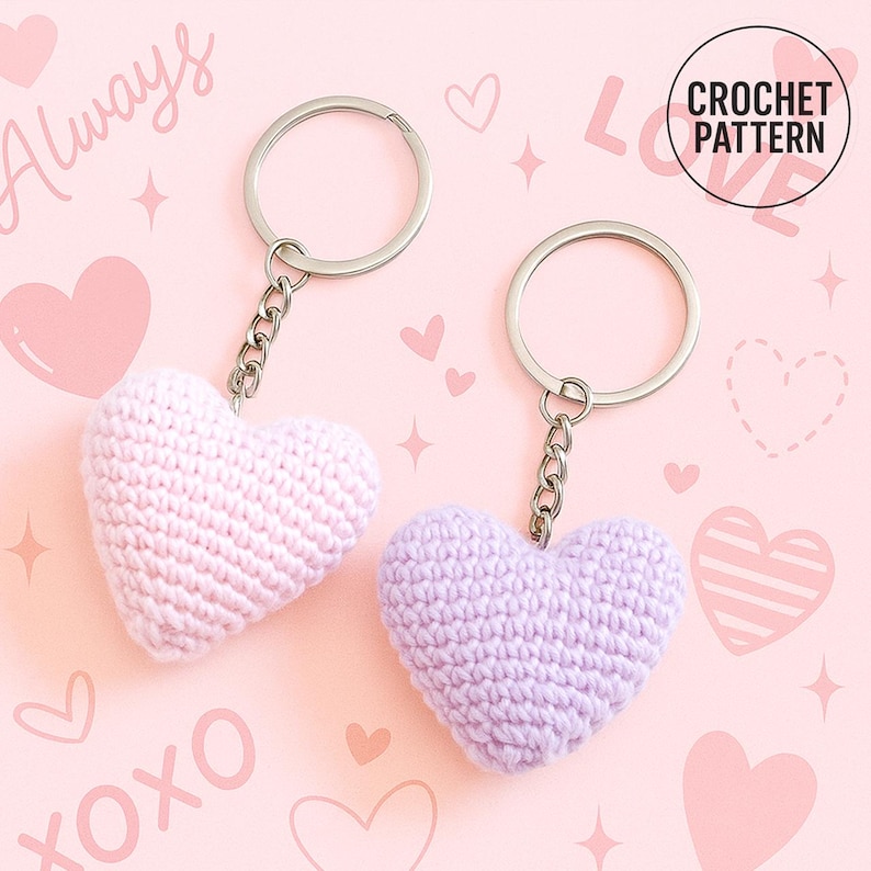 Peut inclure: Deux porte-cl&eacute;s en forme de c&oelig;ur au crochet, un rose clair et un lavande, avec des anneaux et des cha&icirc;nes argent&eacute;s. Le fond est rose avec des c&oelig;urs, des &eacute;toiles et les mots "Always" et "XOXO". Un cercle indique "CROCHET PATTERN".