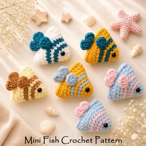 May include: Six small, triangular, crocheted fish toys in various color combinations including white and teal, yellow and teal, yellow and brown, yellow and light blue, and light blue and pink, each with a black bead eye and small fins.
