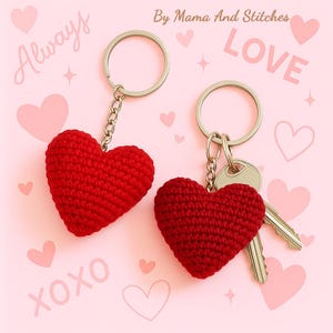 Peut inclure: Deux porte-cl&eacute;s en forme de c&oelig;ur rouge crochet&eacute;, avec des anneaux et des cha&icirc;nes argent&eacute;s. Un porte-cl&eacute;s est accompagn&eacute; de cl&eacute;s. Le fond est rose avec les mots "Always", "Love" et "XOXO" en &eacute;criture manuscrite, ainsi que des illustrations de c&oelig;urs et d'&eacute;toiles.
