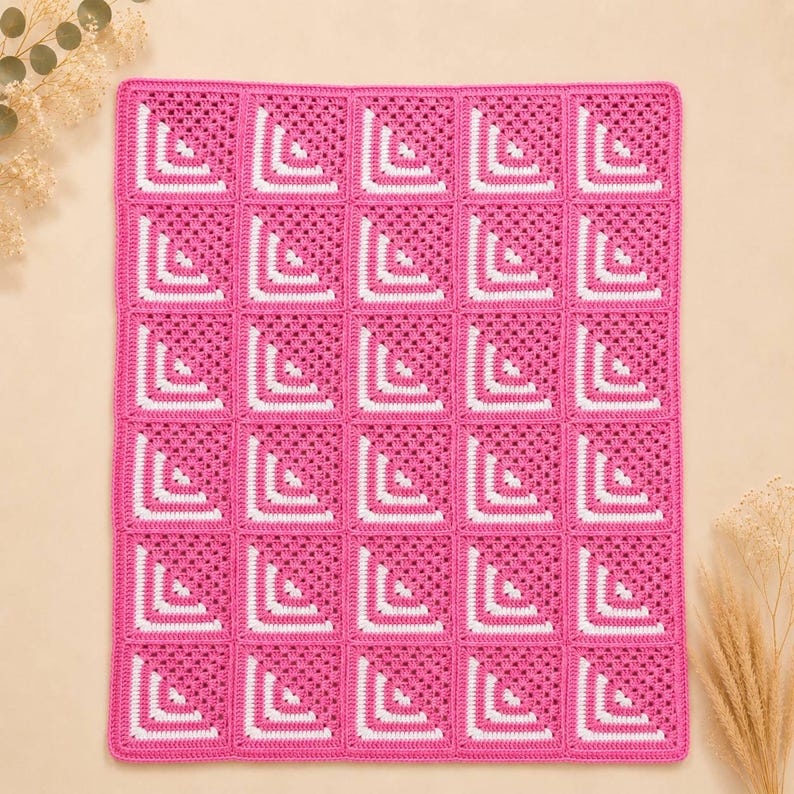 May include: A rectangular crochet blanket composed of thirty individual square motifs. Each square features a vibrant hot pink base with a white L-shaped corner accent. The squares are joined together in a grid pattern to form a cohesive textile piece.
