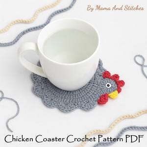 Pode incluir: Uma caneca de cer&acirc;mica branca sobre um porta-copos de croch&ecirc; em forma de galinha cinza com crista vermelha, bico amarelo e um olho. O texto By Mama And Stitches e Chicken Coaster Crochet Pattern PDF &eacute; vis&iacute;vel com fios de l&atilde;.