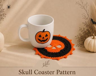 May include: A white ceramic mug featuring an orange jack-o'-lantern graphic, resting on a round, crocheted coaster with a black and orange skull design. The text "Skull Coaster Pattern by Mama And Stitches" is printed at the bottom of the image.