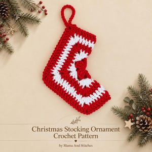 May include: A crochet Christmas stocking ornament featuring a red and white striped pattern with a hanging loop. The text below reads: Christmas Stocking Ornament Crochet Pattern by Mama And Stitches, surrounded by pine branches.