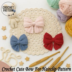 以下が含まれることがあります： ピンク、青、赤色の手編みリボン、かぎ針とかぎ針編み糸。リボンはクリーム色のドイリーに配置され、小さな編みウサギと星型の木製アクセントが付いています。テキストは「Crochet Cute Bow For Hairclip Pattern」と書かれています。