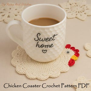 以下が含まれることがあります： 「Sweet home」とハートの文字が入った白いマグカップにコーヒーが入っており、クリーム色の手編みの鶏コースターの上に置かれています。コースターは赤、黄、白の鶏の頭のデザインです。「Chicken Coaster Crochet Pattern PDF」の文字が下にあります。