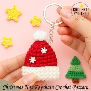 May include: A crocheted Christmas hat keychain in red and white with white snowflake accents. The keychain is held by a silver ring and chain. The image also shows yellow crocheted stars and a green crocheted Christmas tree. The text reads "Christmas Hat Keychain Crochet Pattern."