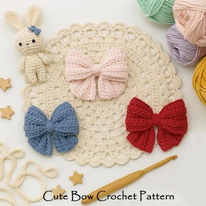 Pode incluir: Laços de crochê rosa, azul e vermelho, dispostos sobre uma toalha de mesa creme. Um coelho de crochê e estrelas de madeira também estão presentes. O texto "Cute Bow Crochet Pattern" está na parte inferior. Meadas de fio no fundo.
