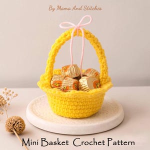 Puede incluir: Una cesta de ganchillo amarilla hecha a mano llena de caramelos envueltos, atada con una cuerda rosa. La cesta está sobre un plato blanco. El texto en la parte superior dice "By Mama And Stitches" y en la parte inferior "Mini Basket Crochet Pattern".
