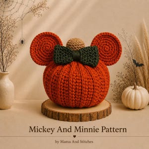 May include: A crocheted orange pumpkin with two large round orange ears, a dark green bow, and a small tan stem on top. The text "Mickey And Minnie Pattern" and "by Mama And Stitches" is printed at the bottom of the image.