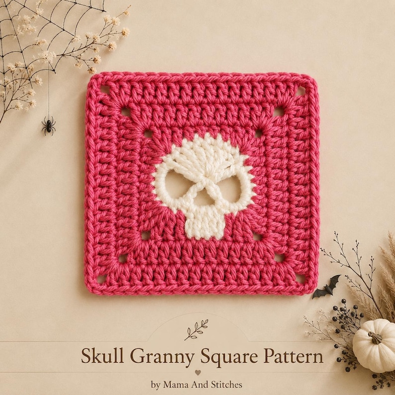 May include: A square crochet piece featuring a hot pink border and a central white skull motif. The text below reads Skull Granny Square Pattern by Mama And Stitches. The design is a flat, hand-stitched textile square with a clear, repeating pattern.