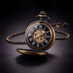 Puede incluir: Un reloj de bolsillo antiguo con esfera negra y números romanos. El reloj tiene una caja de color bronce y un movimiento mecánico visible. Se adjunta una cadena a juego. La tapa del reloj está abierta, revelando los intrincados mecanismos internos.