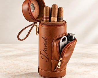 May include: A brown cylindrical cigar case with a zippered top and a side pocket. The case features the name David engraved on the side. It holds three cigars and contains a metal cigar cutter and a lighter inside the zippered side compartment.