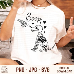 May include: White t-shirt with a black graphic of a skeleton dog being booped on the nose by a skeleton hand. The word "Boop" is written above the dog in a script font, with hearts and stars. The bottom of the image has the text "PNG - JPG - SVG" and "DIGITAL DOWNLOAD".
