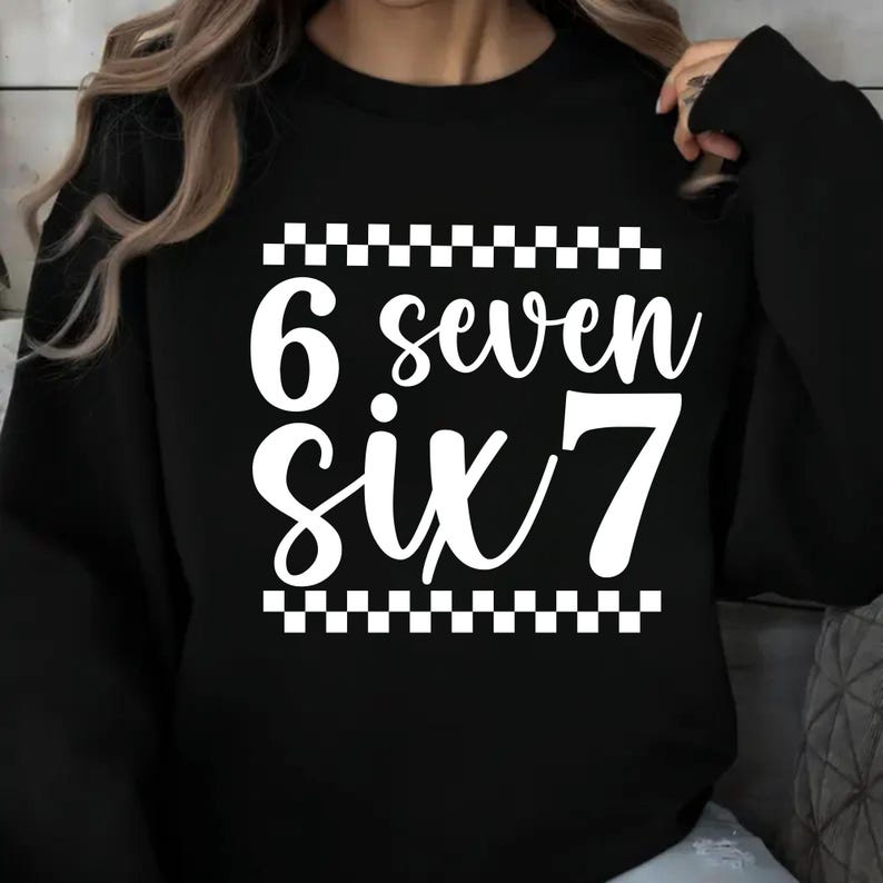 K&ouml;nnte beinhalten: Schwarzes Sweatshirt mit den Zahlen und W&ouml;rtern "6 seven six 7" in Wei&szlig;, mit einem Schachbrettmuster &uuml;ber und unter dem Text. Ein Kleidungsst&uuml;ck im l&auml;ssigen Stil.