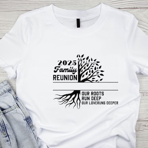 May include: White t-shirt with a black graphic design for a 2025 Family Reunion. The design features a tree with the text "2025 Family Reunion" and the phrase "Our Roots Run Deep, Our Loveruns Deeper."