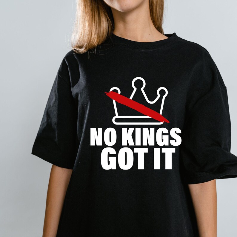 K&ouml;nnte beinhalten: Schwarzes T-Shirt mit dem wei&szlig;en Schriftzug "NO KINGS GOT IT". Dar&uuml;ber befindet sich eine wei&szlig;e Krone mit einem roten Strich. Das T-Shirt hat kurze &Auml;rmel und das Design ist zentriert.