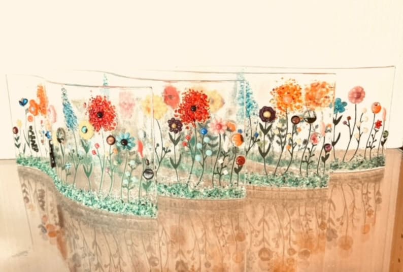 May include: A set of five glass panels with a wavy design, each featuring a colorful floral pattern with red, orange, yellow, blue, and green flowers. The panels are arranged in a row, creating a continuous floral design.