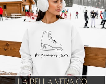 May include: A white long-sleeve sweatshirt featuring a black line art illustration of an ice skate centered on the chest. Below the skate, the text reads for goodness skate in a black cursive font. The sweatshirt has a crew neckline.