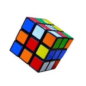 Może przedstawiać: Klasyczna układanka kostki Rubika z czarną ramką i kolorowymi kwadratami w kolorze niebieskim, pomarańczowym, białym, czerwonym, zielonym i żółtym. Kostka to kostka 3x3x3, popularna łamigłówka dla wszystkich grup wiekowych.