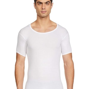 Peut inclure: Un sous-vêtement blanc à manches courtes avec un col rond. Le t-shirt est moulant et fabriqué dans une matière lisse, probablement du coton. Vêtement basique et quotidien.
