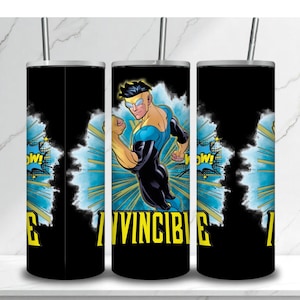 May include: Black tumbler featuring a comic book illustration of a superhero in a blue and black suit with the word "INVINCIBLE" in yellow. The design includes a "WOW!" speech bubble and a blue and white burst background.