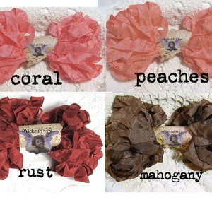 May include: Four fabric bows in coral, peaches, rust, and mahogany. Each bow has a ruffled texture and is adorned with a small tag featuring an illustration and the text "Wicked Pixy". The words "coral", "peaches", "rust", and "mahogany" are written below each bow.