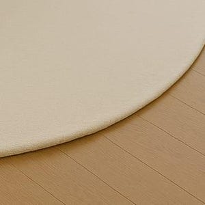 A modern white round rug placed in a beige living room beside large windows with pool and garden view. The soft wool-blend carpet sits under a marble coffee table and cream sofa, creating a bright, elegant, and minimalist interior. Perfect for contemporary, Scandinavian, or neutral-style homes.