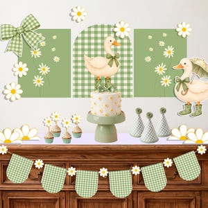 Pode incluir: Um conjunto de decoração de festa com um bolo num suporte verde, cupcakes, chapéus de festa e uma bandeirola. O tema inclui margaridas brancas, padrões de xadrez vichy verdes e ilustrações de patos com botas verdes e laços.