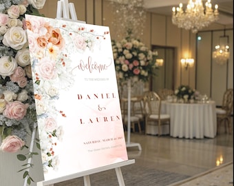 Peut inclure: Un chevalet blanc supporte un panneau de bienvenue de mariage avec des accents floraux. Le panneau indique "Welcome" au-dessus des noms "Daniel & Lauren" en écriture cursive. Le panneau est décoré de fleurs aquarelles roses, pêche et blanches.