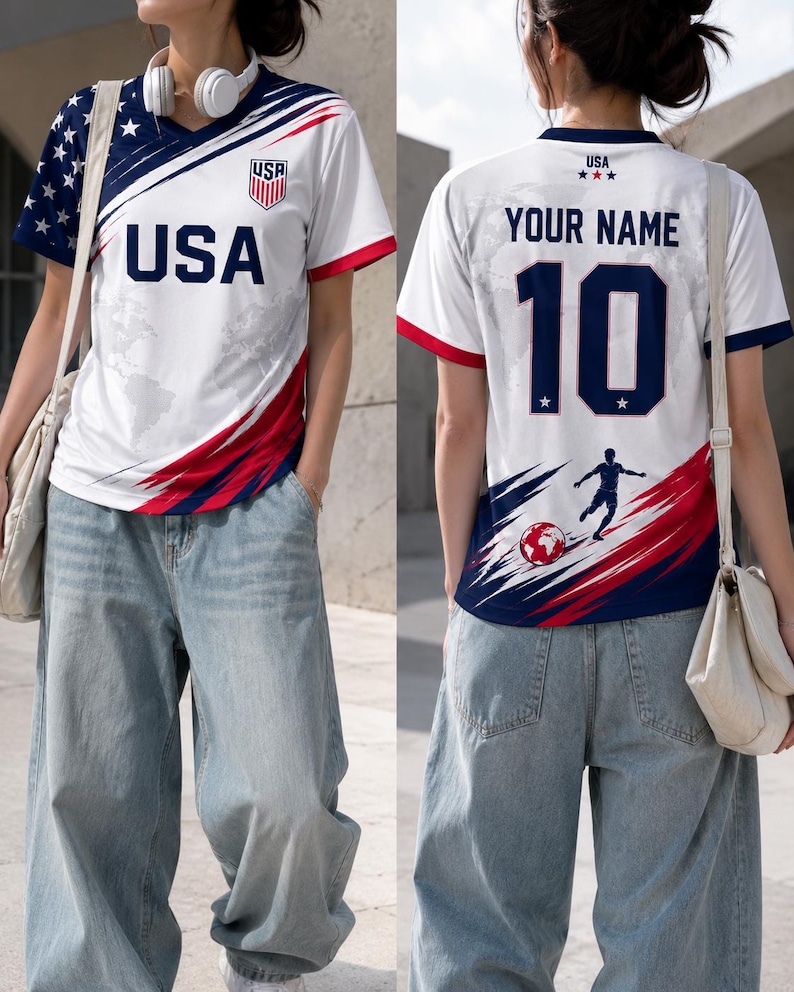 May include: White soccer jersey with red and blue accents, featuring "USA" and a shield emblem on the front. The back displays "YOUR NAME" and the number "10", with a soccer player graphic. The sleeves have a blue star pattern.
