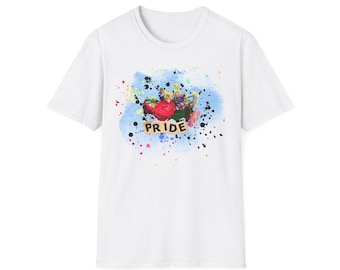 Op de afbeelding: Een wit t-shirt met korte mouwen en een centrale afbeelding van een kleurrijk boeket bloemen tegen een blauwe aquarelachtergrond met zwarte verfspatten. Het woord PRIDE staat in zwarte hoofdletters op een beige rechthoekige banner.