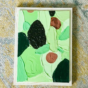 May include: Abstract painting in a white wooden frame. The artwork displays a textured surface with shades of green, brown, and black. The design incorporates organic shapes and brushstrokes, offering a contemporary artistic feel.