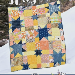 May include: A patchwork quilt titled Stargazer featuring a variety of yellow, orange, and dark blue fabric squares with star patterns and geometric prints. The quilt is labeled Running Doe Quilts for Villa Rosa Designs at the bottom.