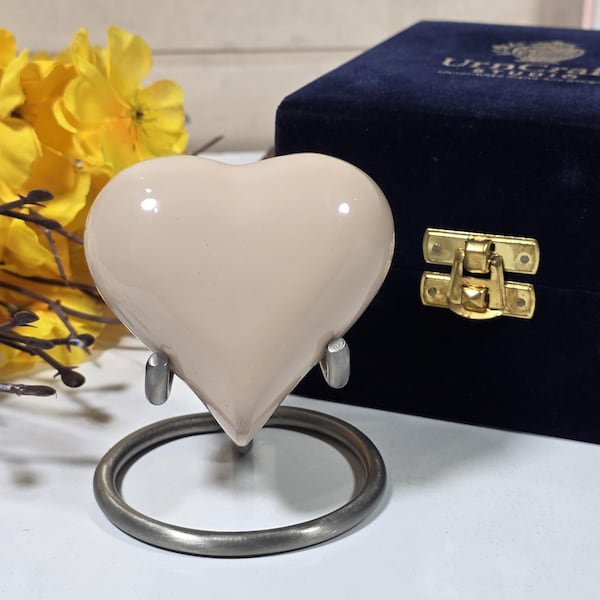 Urna conmemorativa personalizada en forma de corazón para cenizas, con soporte metálico y caja de terciopelo.