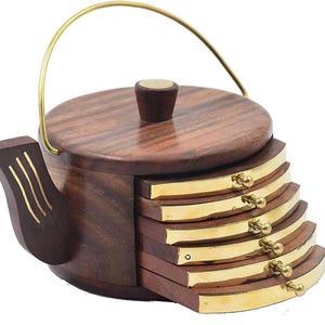 May include: A wooden teapot-shaped coaster set with a brass handle and accents. The set includes six coasters that slide out from the base. The coasters and the teapot are made of dark brown wood with brass trim.