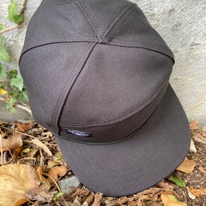 May include: A black canvas baseball cap with a flat brim and a small logo on the front.