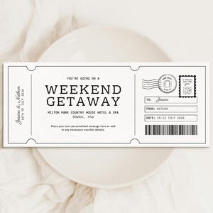 Pode incluir: Um design de bilhete a preto e branco para uma escapadela de fim de semana. O bilhete inclui o texto "WEEKEND GETAWAY", a data "10-12 JULHO 2026" e os nomes "Jessica & Nathan". Também tem um selo e um código de barras.